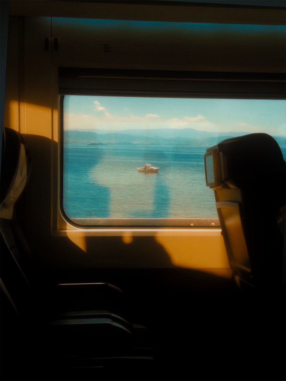 scenic train view of tranquil waters and boat